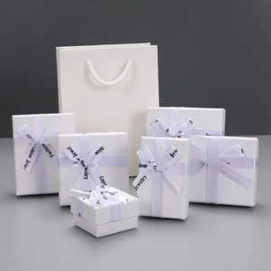 Detailed view of white textured jewelry boxes and matching gift bags with Fashion Jewelry ribbons