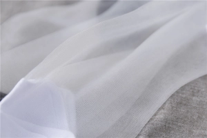 Close-up of white sheer mesh fabric showing fine hexagonal breathable net structure