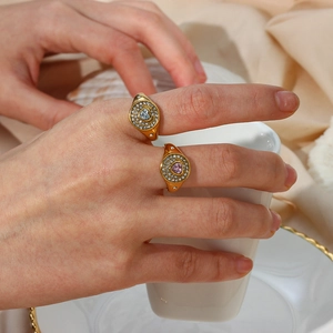 Close-up of 18K gold plated heart rings with pink and white zircon stones on fingers