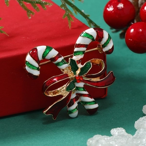 Detail of candy cane Christmas brooch with red bow and green holly leaves on red gift box