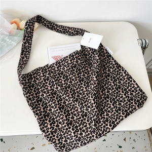 Macro shot of the leopard print canvas tote bag side label and woven strap detail