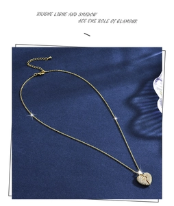 Detailed view of gold heart pendant necklace with shimmering zircon inlay on velvet