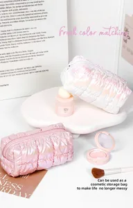 Detailed view of quilted holographic puffy makeup bags in pearl white and rose pink