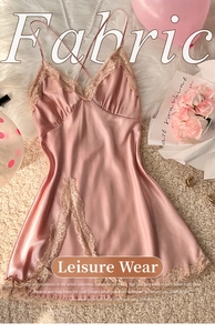 Detail of pink satin nightgown featuring V-neck lace trim and delicate cross-back straps