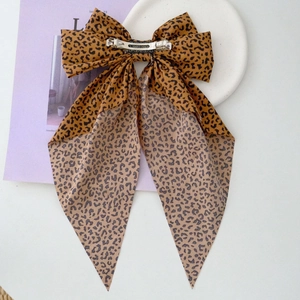 Macro shot of silver metal spring clip and leopard print ribbon on handmade bow