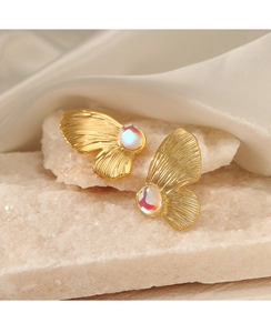 Detailed close-up of golden butterfly wing earrings with iridescent opal stones and silk