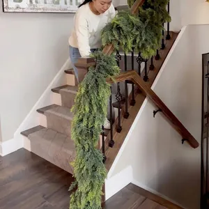 Realistic cedar Christmas garland hanging on wooden staircase for festive home decoration