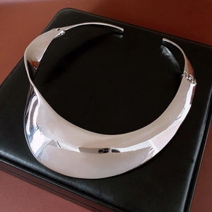 Macro shot showing the detailed hinge and twisted sculptural structure of the silver choker