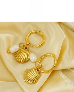 Dettaglio di orecchini a ventaglio placcati oro 18K con perle su sfondo di seta