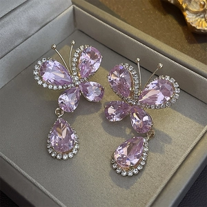 Détail de boucles d'oreilles papillon violettes de luxe avec pendentifs goutte en zircone