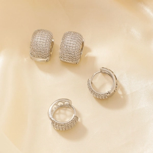 Parure de boucles d'oreilles en argent avec oxydes de zirconium sur un tissu en soie champagne