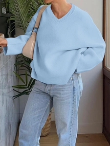Women casual light blue V-neck knitted sweater paired with denim jeans and beige bag