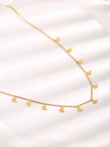Detailed view of titanium steel gold butterfly necklace on white silky fabric