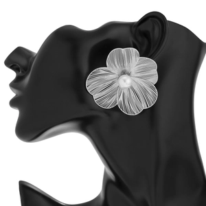 Close-up of a silver ginkgo leaf earring with a pearl on a black mannequin