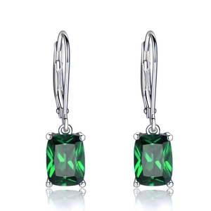 Detailed macro view of square emerald green gemstone drop earrings with silver finish