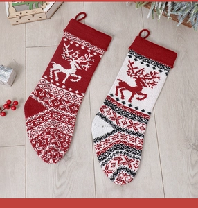 Close-up of knitted Christmas stockings with reindeer patterns on a wooden floor