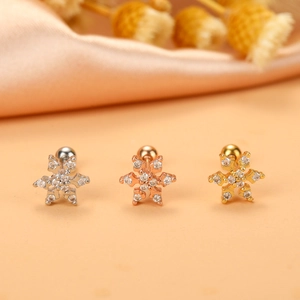 Detailed view of three snowflake cartilage earrings in silver, rose gold, and gold finishes