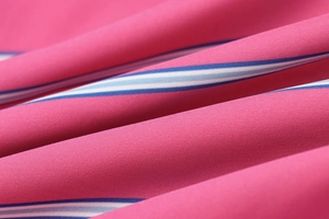 Macro shot of pink, blue, and white striped fabric texture with pleated details and fine weave