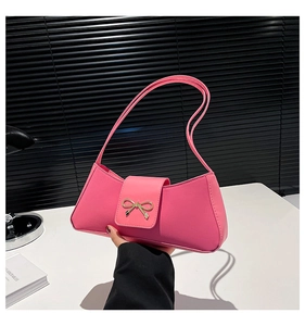 Detailed close-up of pink PU leather baguette bag featuring a gold bow metal buckle