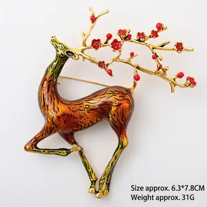 Detail of vintage elk brooch with red plum blossom antlers and orange enamel deer body