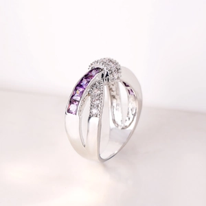 Detailed close-up of crossover silver ring with purple zircon stones and pavé diamonds