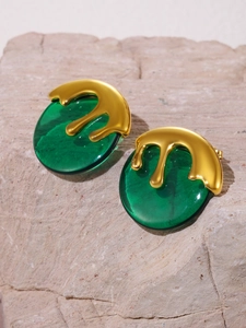 Macro detail of emerald green resin earrings with gold fluid lava aesthetic design