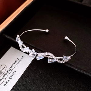 Macro shot of silver-toned flower bracelet with blue zircons in a black jewelry box