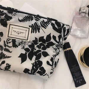 Detailed flat lay of floral puff cotton makeup bag with black zipper and woven label
