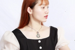 Detail of vintage stainless steel necklace featuring a colorful floral pendant on a model