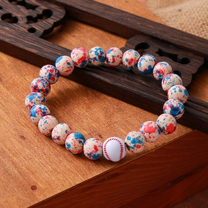 Close-up of beaded bracelet with red baseball pattern bead and colorful turquoise beads