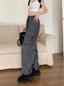 Detailed view of dark grey cargo pants featuring side flap pockets and cuffed hems