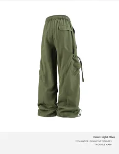 Dettaglio dei pantaloni cargo verde militare chiaro con coulisse e tasche laterali a patta