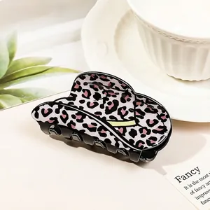 Close-up of a glossy leopard print hair claw clip in a stylish lifestyle setting