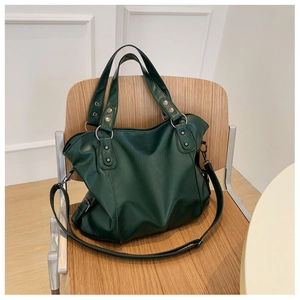 Detailed view of large dark green leather tote bag with handles and long shoulder strap