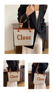 Detail of beige canvas tote bag with brown leather trim and Cloos lettering accent