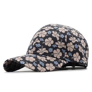 Navy floral baseball cap with tropical hibiscus pattern in a stylish 45-degree side view