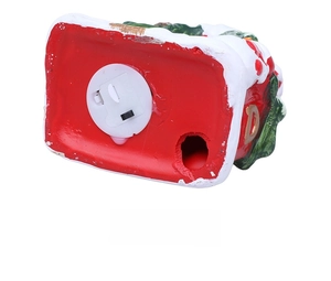 Close-up of the ceramic Christmas house base showing the LED power switch and battery compartment