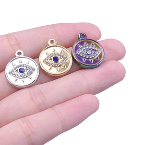 Gros plan de pendentifs Mauvais Œil en acier inoxydable plaqué or 18 carats, or, argent et couleur