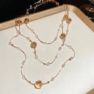 Elegant gold French beaded necklace with amber crystal accents on a luxury tray