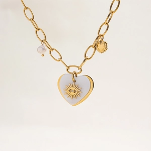 Detail of 18K gold stainless steel heart pendant with pearl and shell sun motif