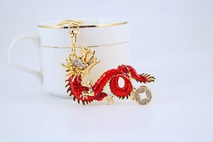 Close-up of golden zodiac dragon keychain with red enamel and sparkling rhinestones