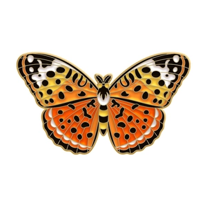 Detailed view of colorful butterfly enamel brooch with intricate orange and yellow patterns
