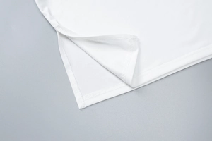 Détail de l'ourlet fendu sur le côté d'un haut licou blanc moulant en tissu lisse