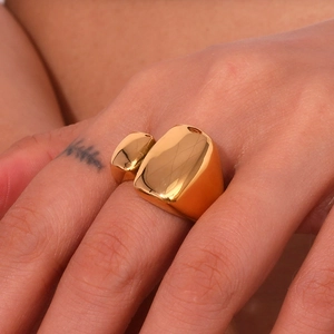 Gros plan d'une bague rectangulaire géométrique plaquée or sur le doigt d'un mannequin