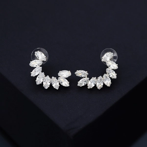 Macro detail of fan-shaped stud earrings with marquise-cut zircons on a black display