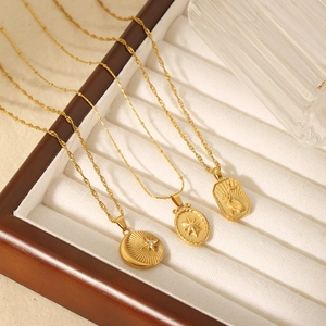Trois colliers en acier titane plaqué or 18K avec pendentifs étoile et lune dans un coffret
