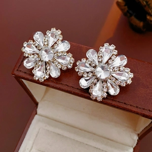 Detailed view of flower-shaped crystal earrings on a jewelry box with sparkling diamonds