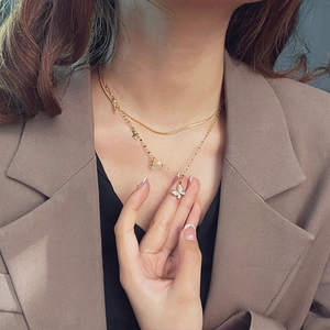 Elegant gold double-layer titanium steel necklace featuring butterfly and star pendants