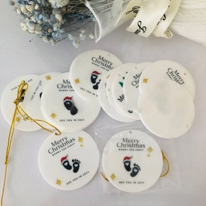 Detail of round Christmas ornament with baby footprints and 'Mommy and Daddy' text