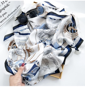 Detailed macro view of white silk scarf with nautical blue and brown anchor patterns